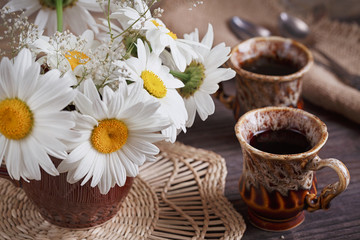 Fototapeta na wymiar White wild daisy flowers in a vase on the old table