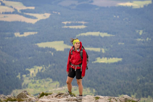 Young woman resting at top of the mountain after difficult ascent. Hiking in High Tatras National Park, Slovakia.