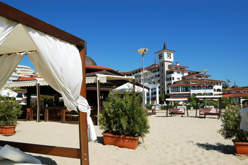 Clocktower and ambrellas on the beach. © dragunoff