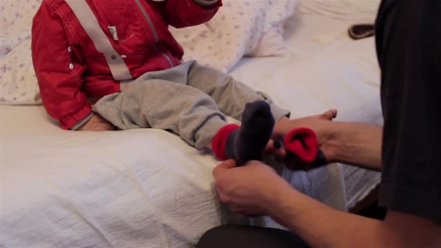 wear socks to baby/Dad puts his young son on his feet socks