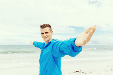 Young man in sport wear with outstretched arms