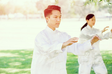 People practicing thai chi in park