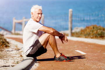 Man in sports wear sitting at the beach