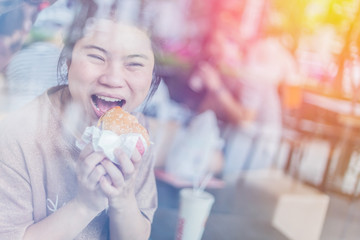cute smiling girl eating hamburger in restaurant