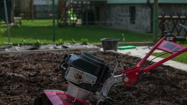 Plowing in a garden is done and the cultivator is turned off. A garden is now ready for growing new vegetables. Wide-angle shot.

