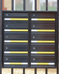 12 numbered letterboxes outside building