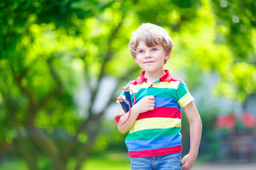 little kid boy shooting wooden slingshot