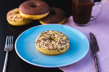 Sweet glazed donuts on plate and coffe. Breakfast serving on table.