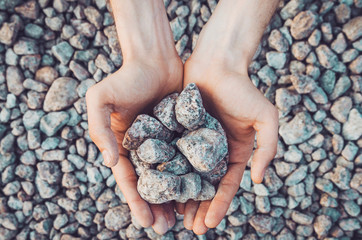 Inner balance concept: hands holding stones, land background. Earth day, eco friendly. Nature wallpaper. Symbol of environment and new life, growth ecology.
