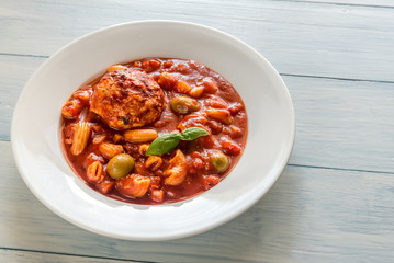 Portion of minestrone soup with meatball