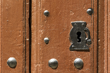 old wooden door with locks and handle of rusty iron , background