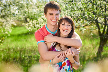 Young couple enjoying in blooming garden