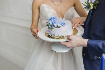 Obraz na płótnie Canvas Bride and groom at wedding hold wedding cake