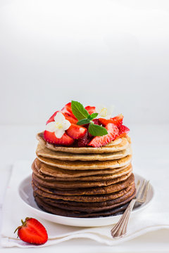 Ombre chocolate pancakes with fresh strawberry on white backgrou