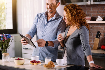 Couple looking at tablet while having breakfast