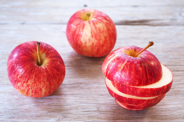 Close up of slice and whole apple on a wooden table.