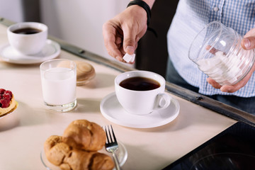 Man putting sugar to coffee