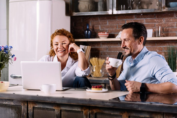 Couple looking at laptop while having breakfast