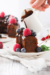 Delicious Chocolate cake with summer berries, white wooden table, selective focus