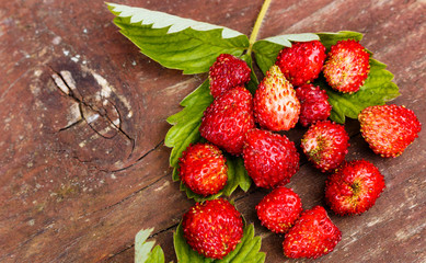Strawberry with green leaves on wooden table