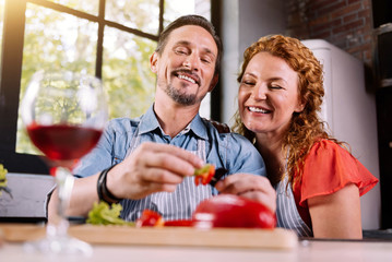 Man peeling vegetable near woman