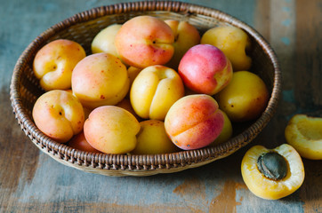 Fresh apricots in the basket on a wooden table in rustic style