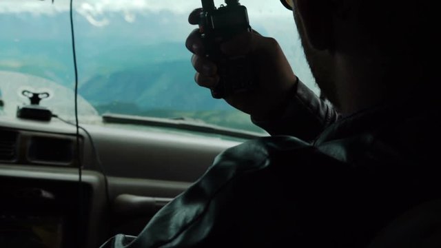 rescuer hitchhiker with orange suitcase stopping car on the mountain road