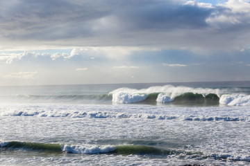 Obraz premium Ocean Waves crashing water power long rocky beach 