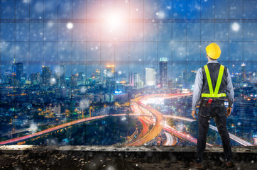 Double exposure of Engineer holding yellow helmet.