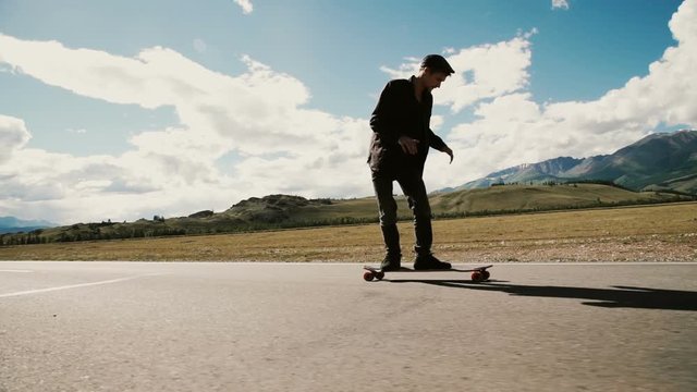 Slow Motion Skateboarder Riding Down Hill At Sunset
