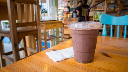  ice chocolate in plastic glass on wood table