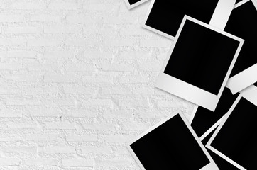 Blank photo papers on white wall background.