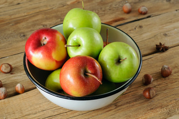 Red and green apples in a white bowl