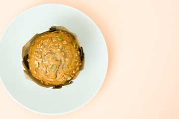 Muffin on a plate on brown background

