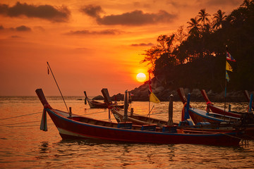 Thai fishing boats during sunset at Kata beach, Phuket, Thailand