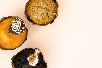Delicious variety of muffins on brown background

