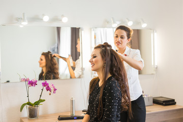 Hairdresser doing hair style for woman. Concept of fashion and beauty