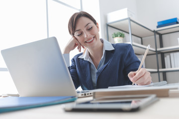 Businesswoman writing notes on a notebook