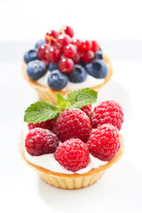 mini cakes with cream and fresh berries, vertical closeup