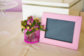 Blank photo frame and flowers bouquet. Over wooden table