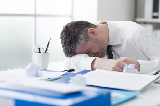 Exhausted businessman sleeping on his desk