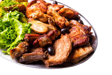 Grilled chicken wings and legs with lettuce and black olives