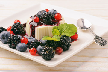Panna cotta with berry mousse and berries.