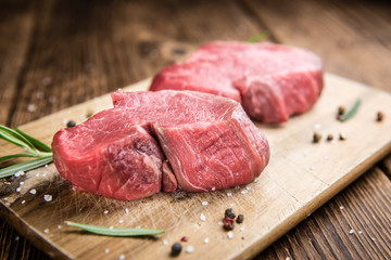 Old wooden Table with raw Beef Fillet