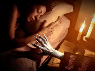 devil hand coming out from horror book on Halloween night