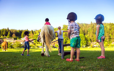 Children riding  horse, horse riding school