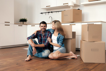 Girlfriend hugging boyfriend on floor in kitchen