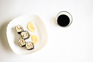 Sushi maki with lemon slices on the white plate