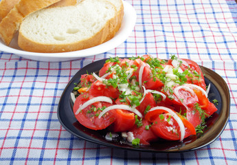 Dining table with a plate of bread and a bowl of vegetarian sala