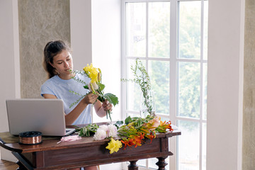 Florist working with bright flowers in workshop